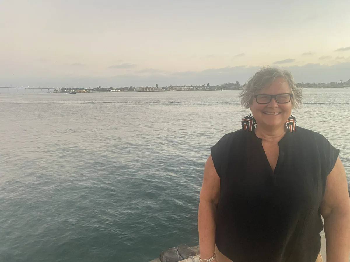 Photograph: Janine Westlund smiling, by the water at dusk